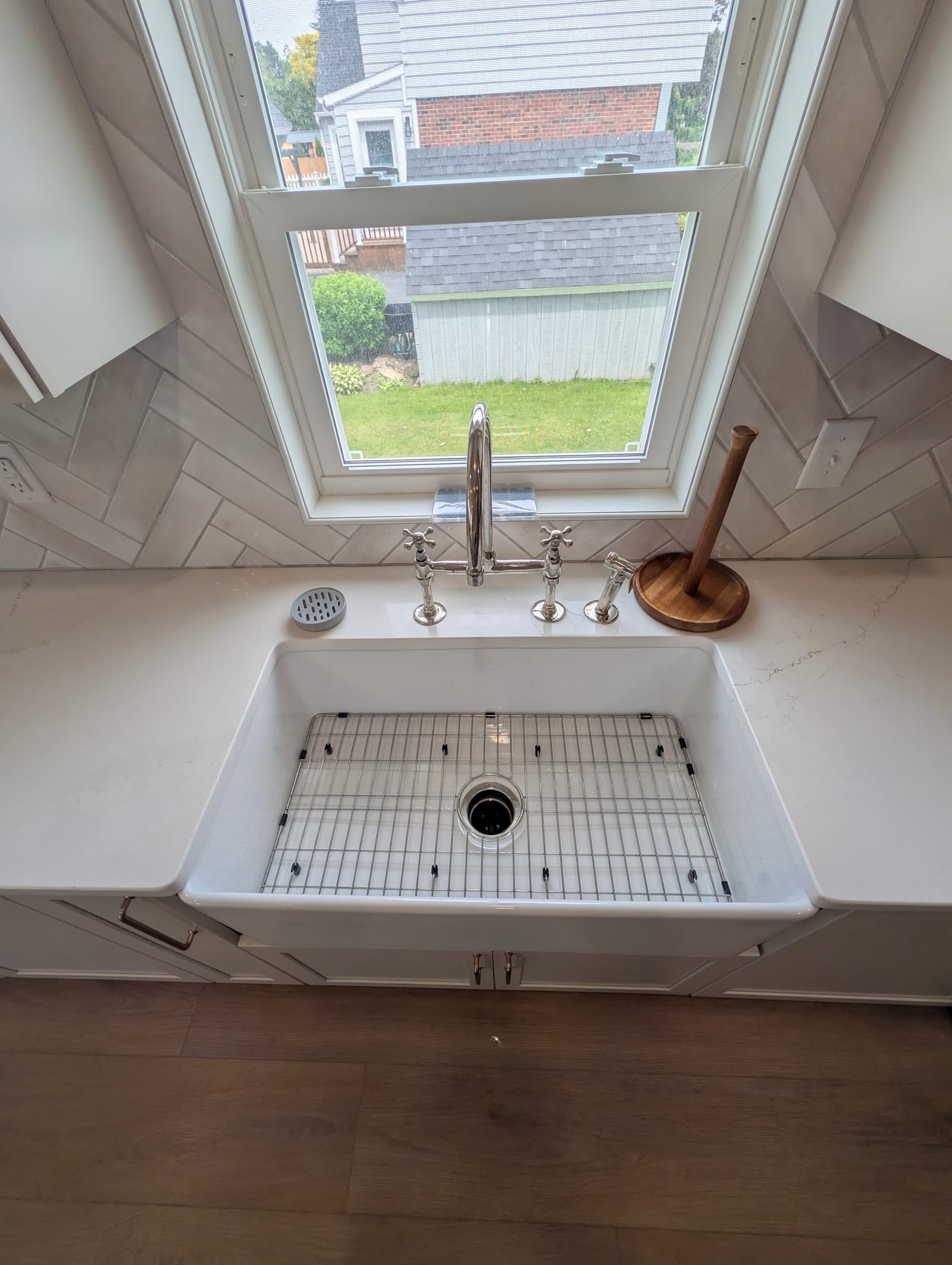 A farmhouse sink, scrubbed clean, under a kitchen window.