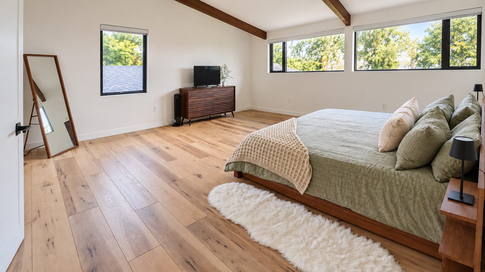A guest bedroom made up fresh, the bed made and the floor clear.